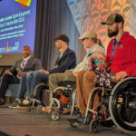 New England PVA Leaders Participate in Christopher & Dana Reeve Foundation Summit-Wheelchair users on stage with speaker.